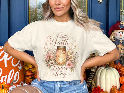 Cream t-shirt with "A Little Faith Lights the Way" on a flowing mason jar design.