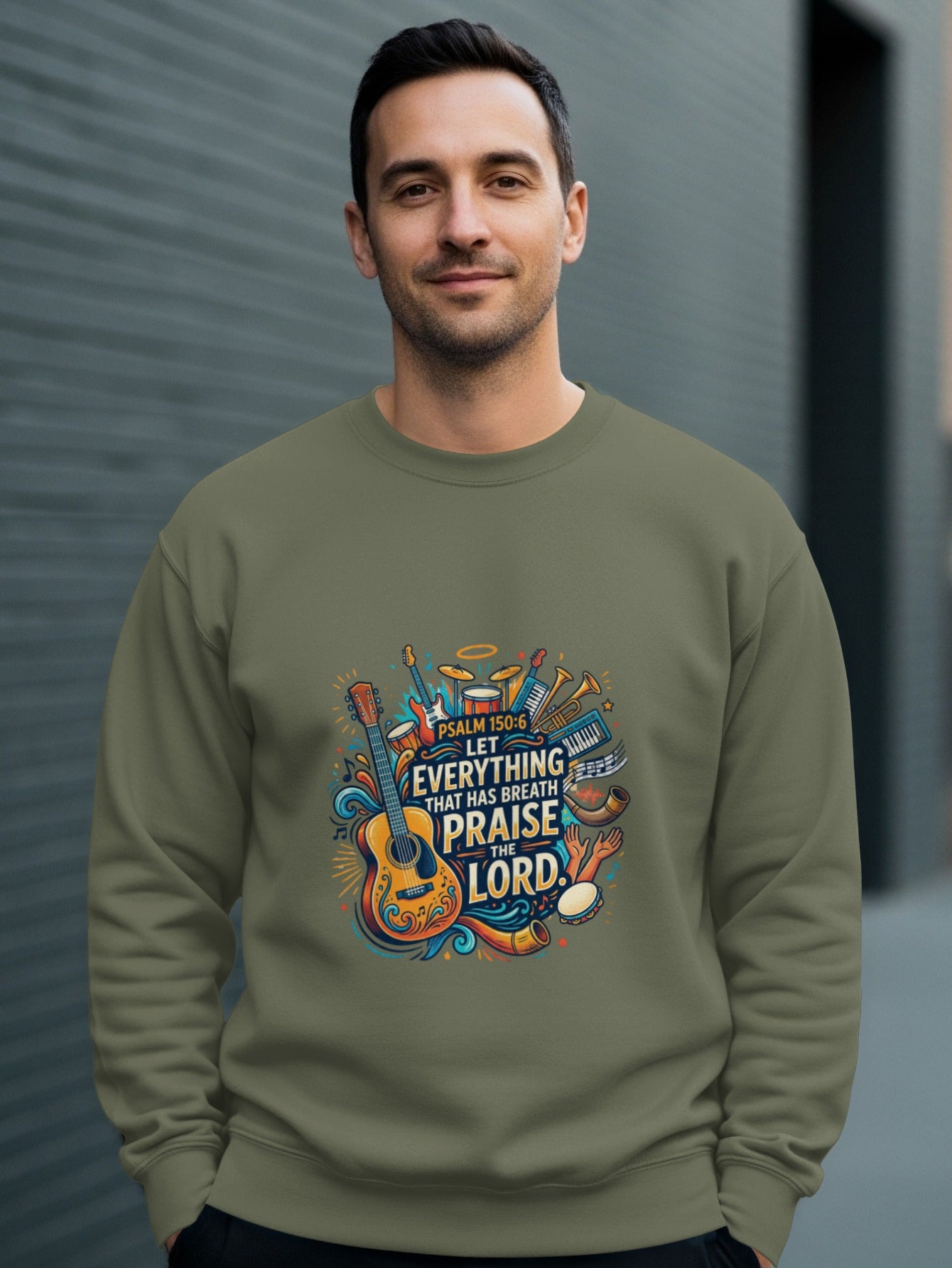 Man wearing olive green sweatshirt with musical instruments and Psalm 150:6 text graphic.