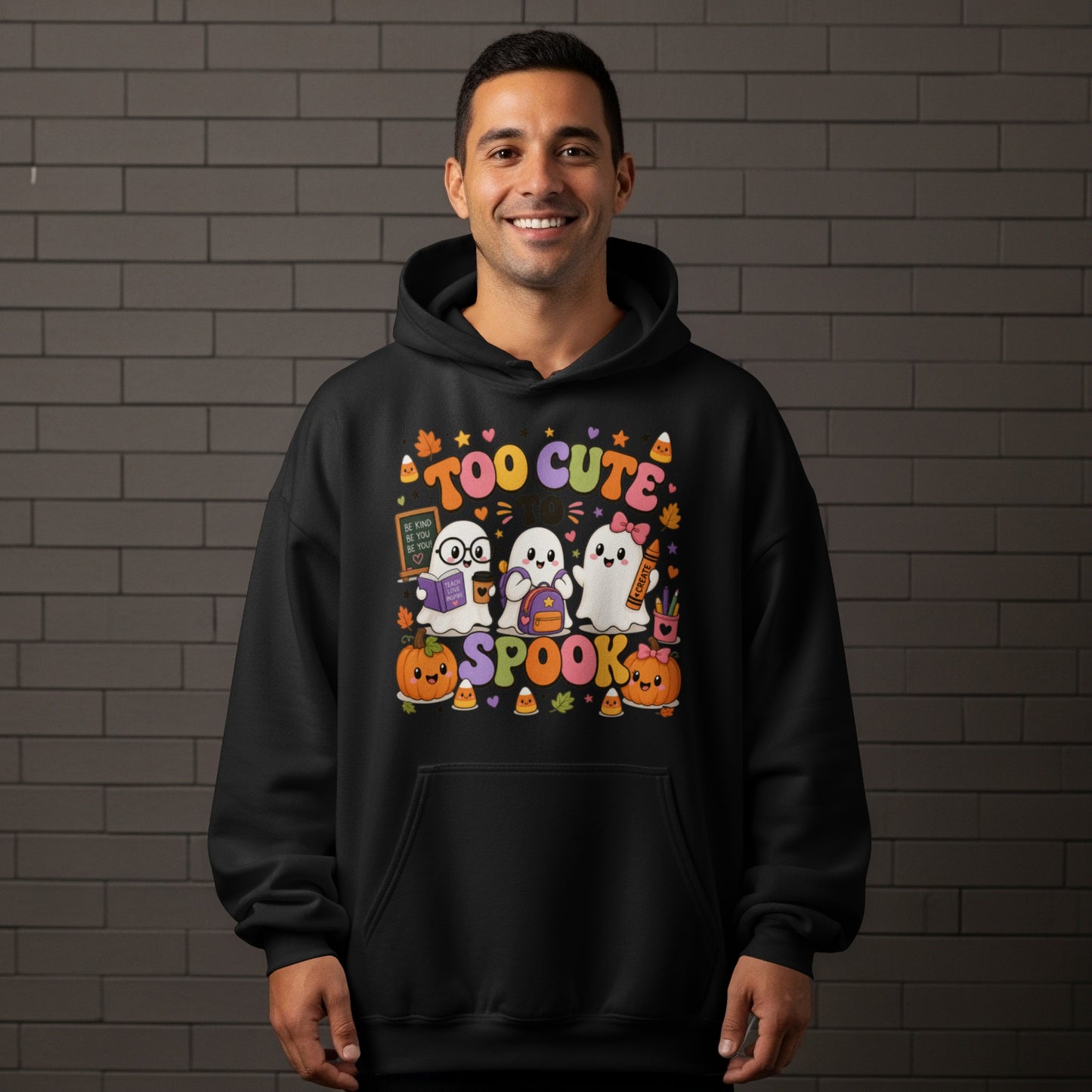 Black hoodie with "Too Cute to Spook" Halloween graphic featuring ghosts, pumpkins, and candy corn.