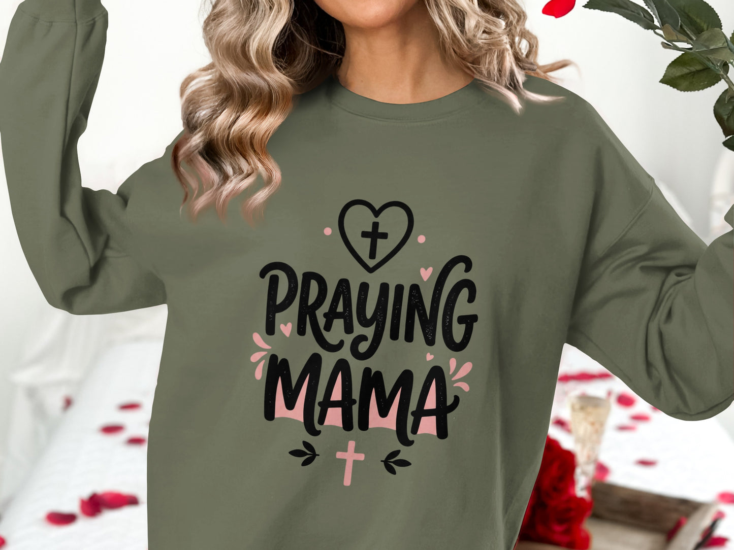 Green sweatshirt with "Praying Mama" graphic and heart, cross, and floral accents.
