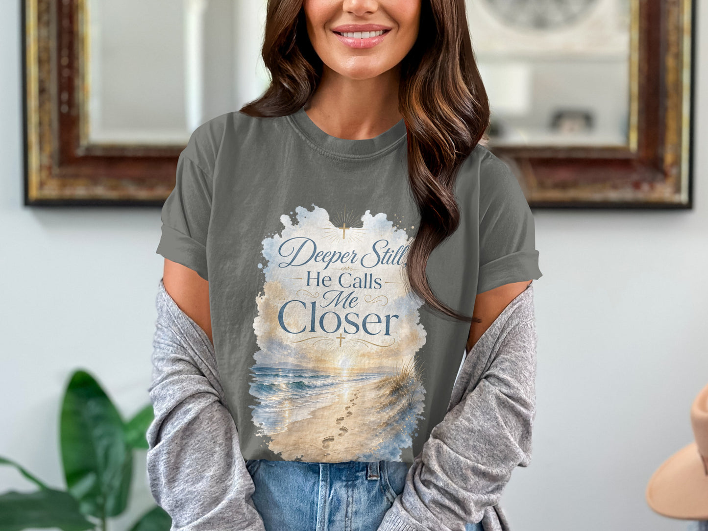 Dark grey t-shirt with "Deeper Still He Calls Me Closer" text and beach scene design.