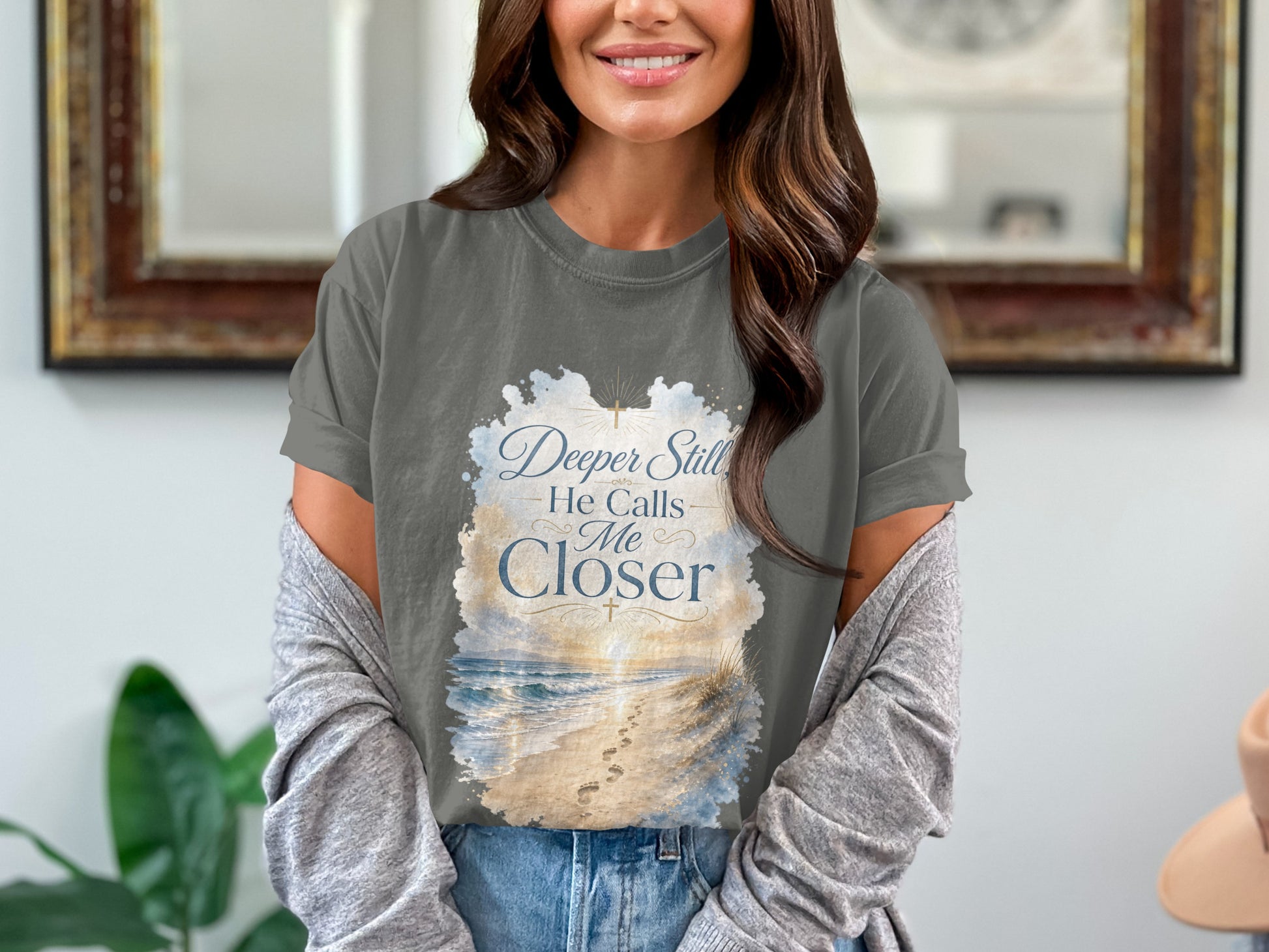 Dark grey t-shirt with "Deeper Still He Calls Me Closer" text and beach scene design.