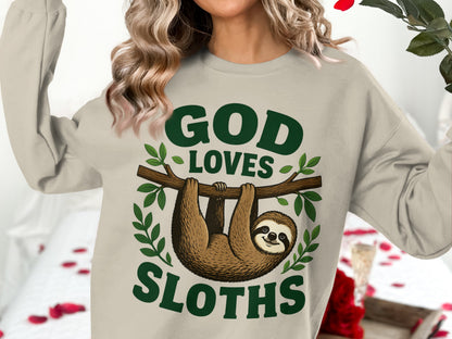 Light beige sweatshirt with "God Loves Sloths" text and a hanging sloth graphic.