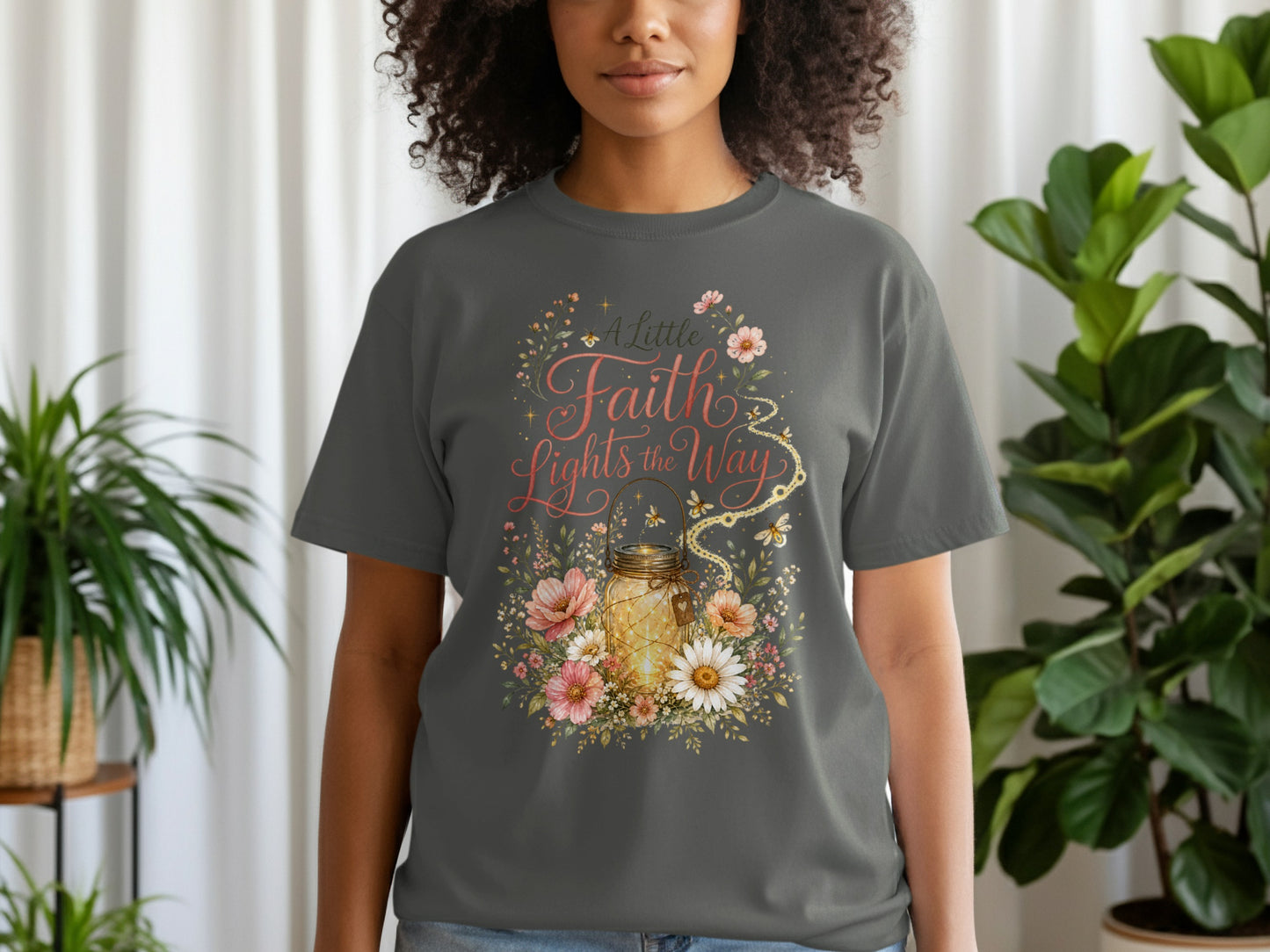 Gray t-shirt with floral design featuring a lit mason jar and text "A Little Faith Lights the Way".
