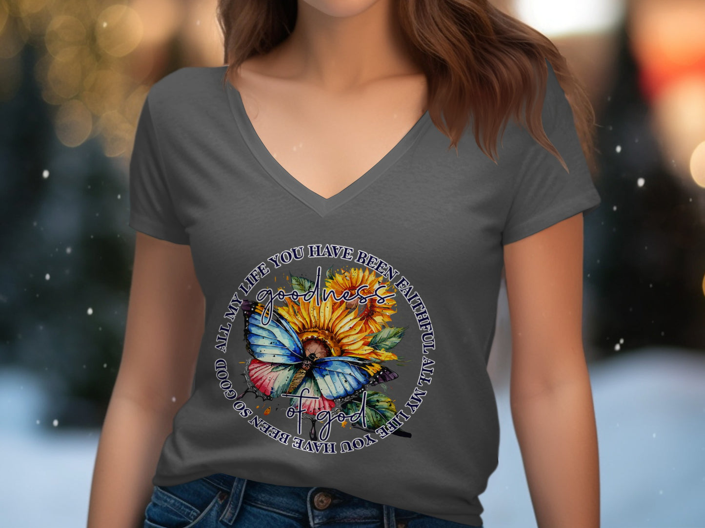 Woman wearing dark grey v-neck t-shirt with sunflower and butterfly graphic.