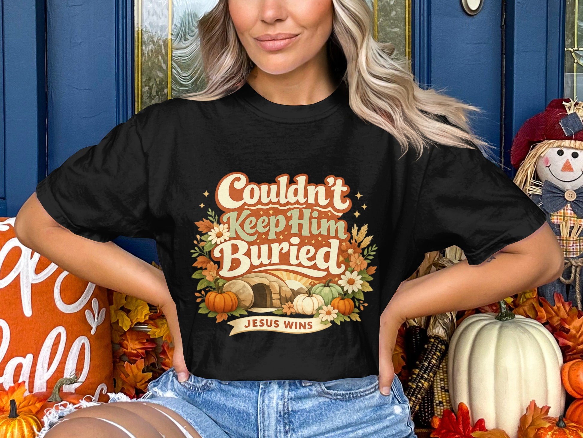 Black t-shirt with tomb, pumpkins, flowers, and text "Couldn't Keep Him Buried JESUS WINS".