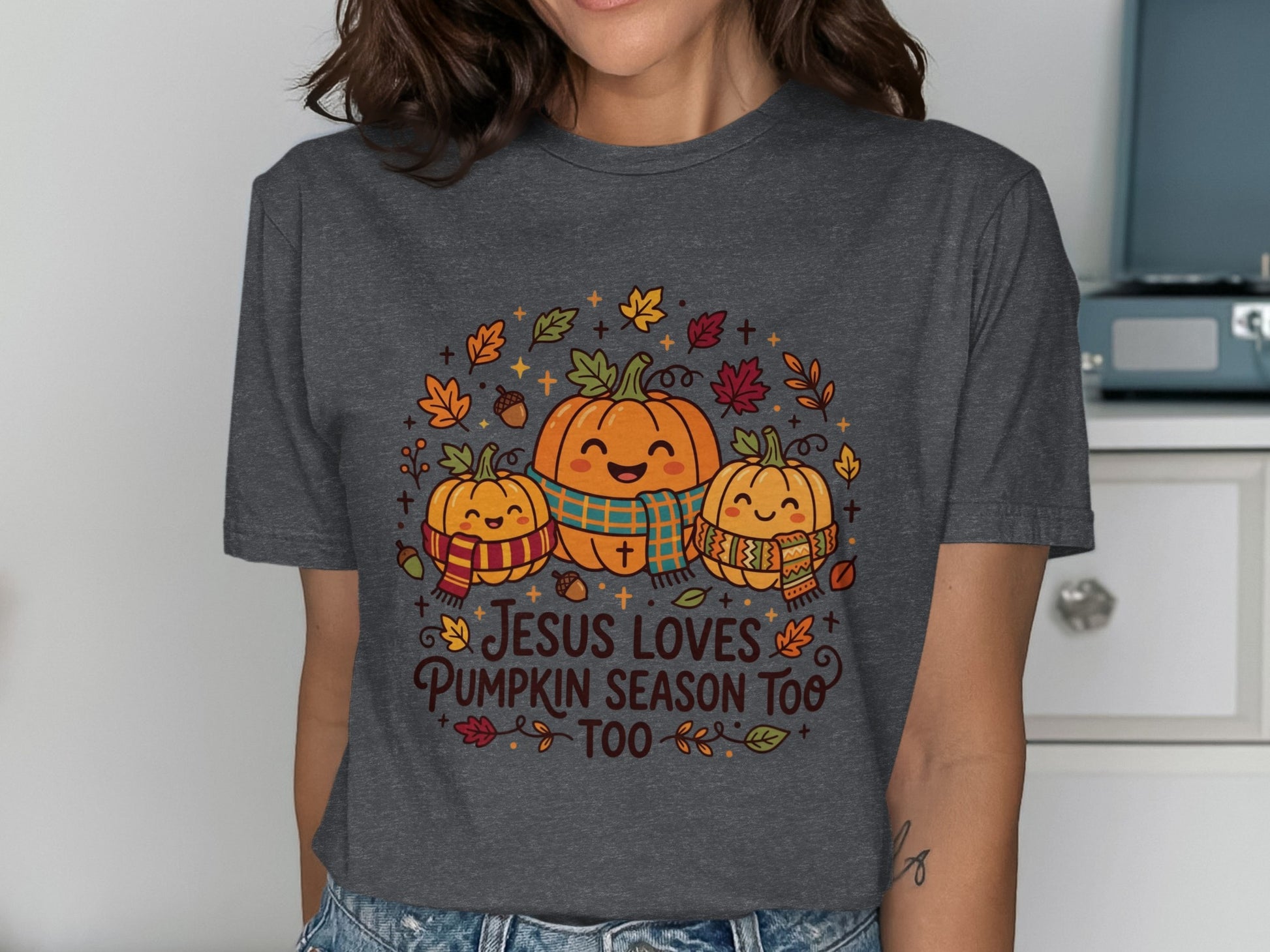 Three smiling pumpkins with scarves and fall leaves, "Jesus loves pumpkin season too" text.