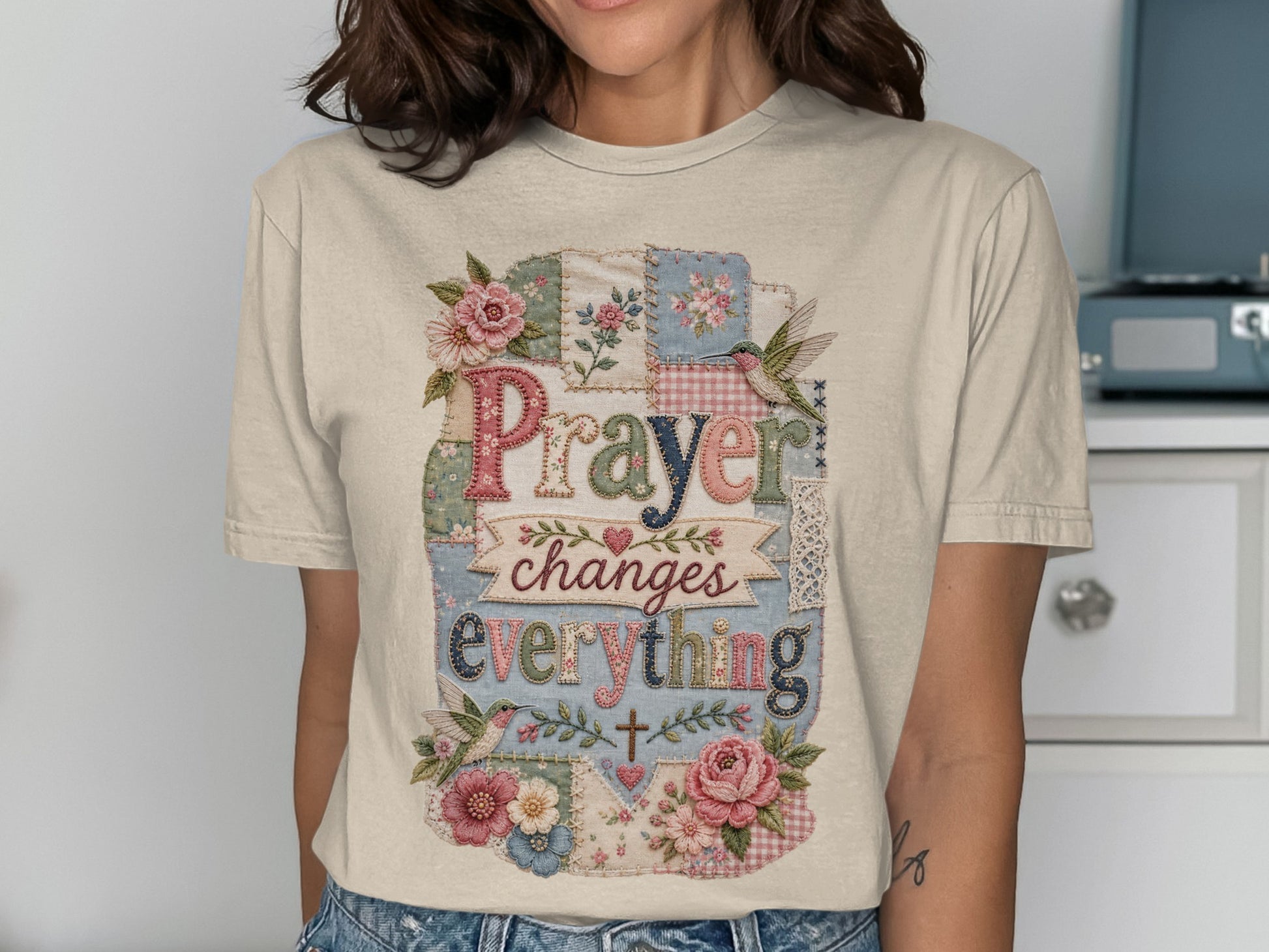 T-shirt with "Prayer changes everything" text, framed by floral and bird patchwork.