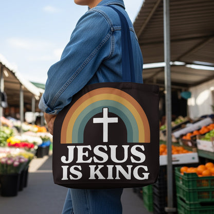 Black tote bag with a rainbow and cross graphic and "JESUS IS KING" text.