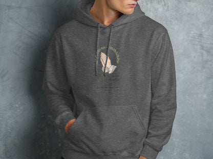 Dark grey hoodie with floral wreath and prayer hands, featuring Bible verse.