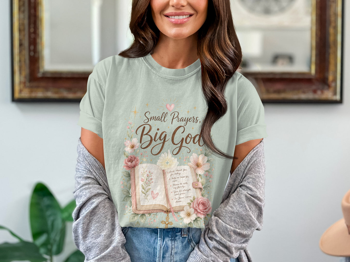 Light sage green t-shirt with "Small Prayers, Big God" and floral open book graphic.