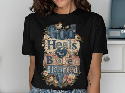Black t-shirt with "God Heals The Broken Hearted" text and floral designs.