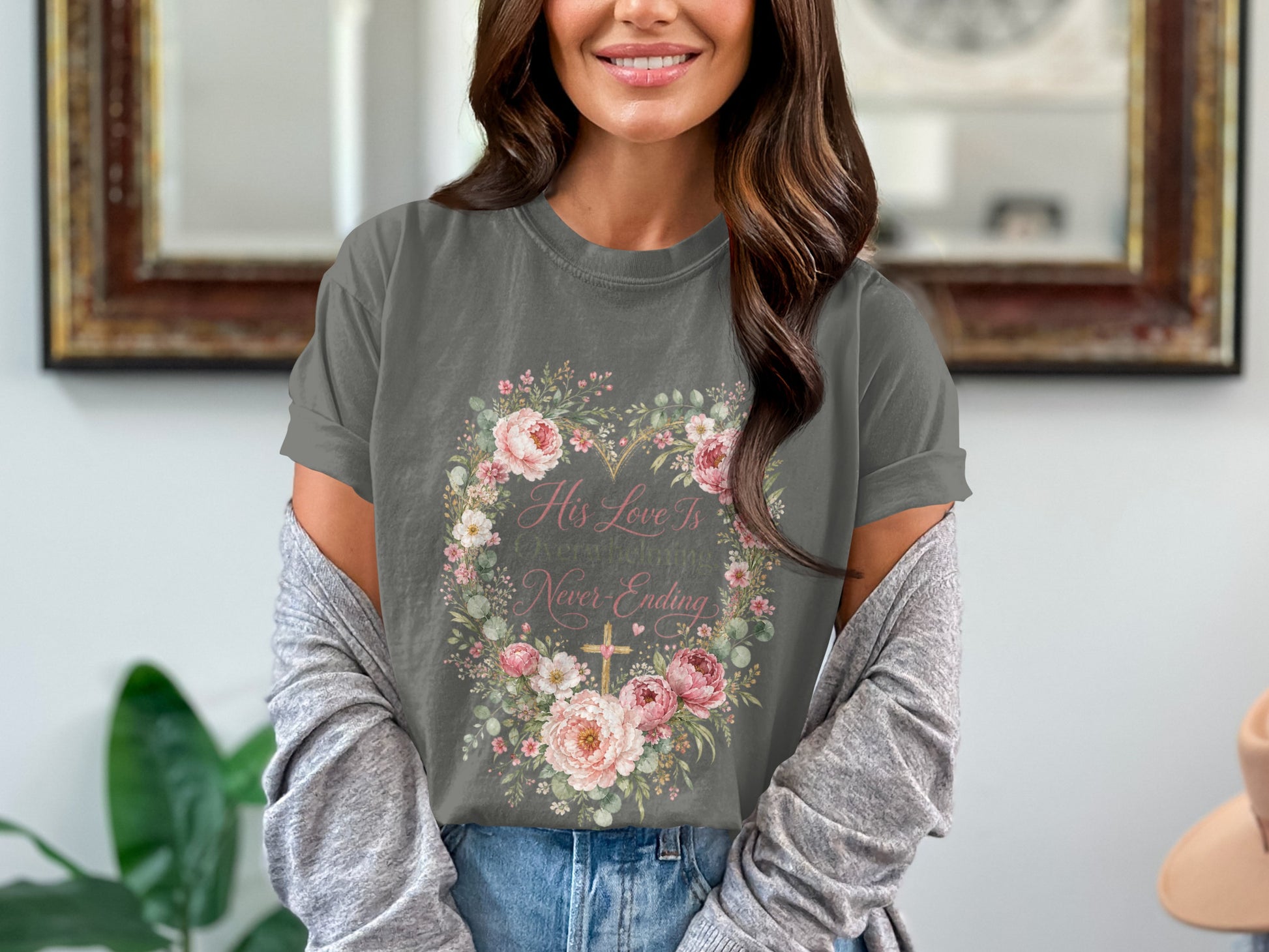 Gray t-shirt features "His Love Is Never-Ending" with floral heart and cross design.