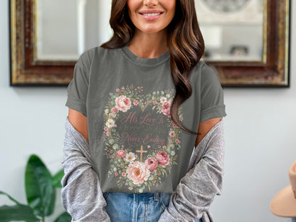 Gray t-shirt features "His Love Is Never-Ending" with floral heart and cross design.