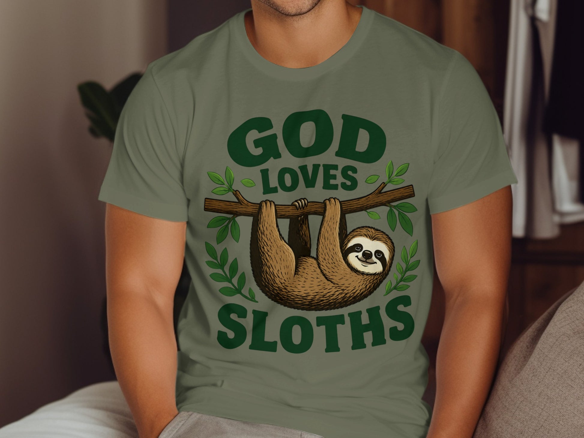 Green t-shirt with "God Loves Sloths" text and a sloth hanging on a branch.