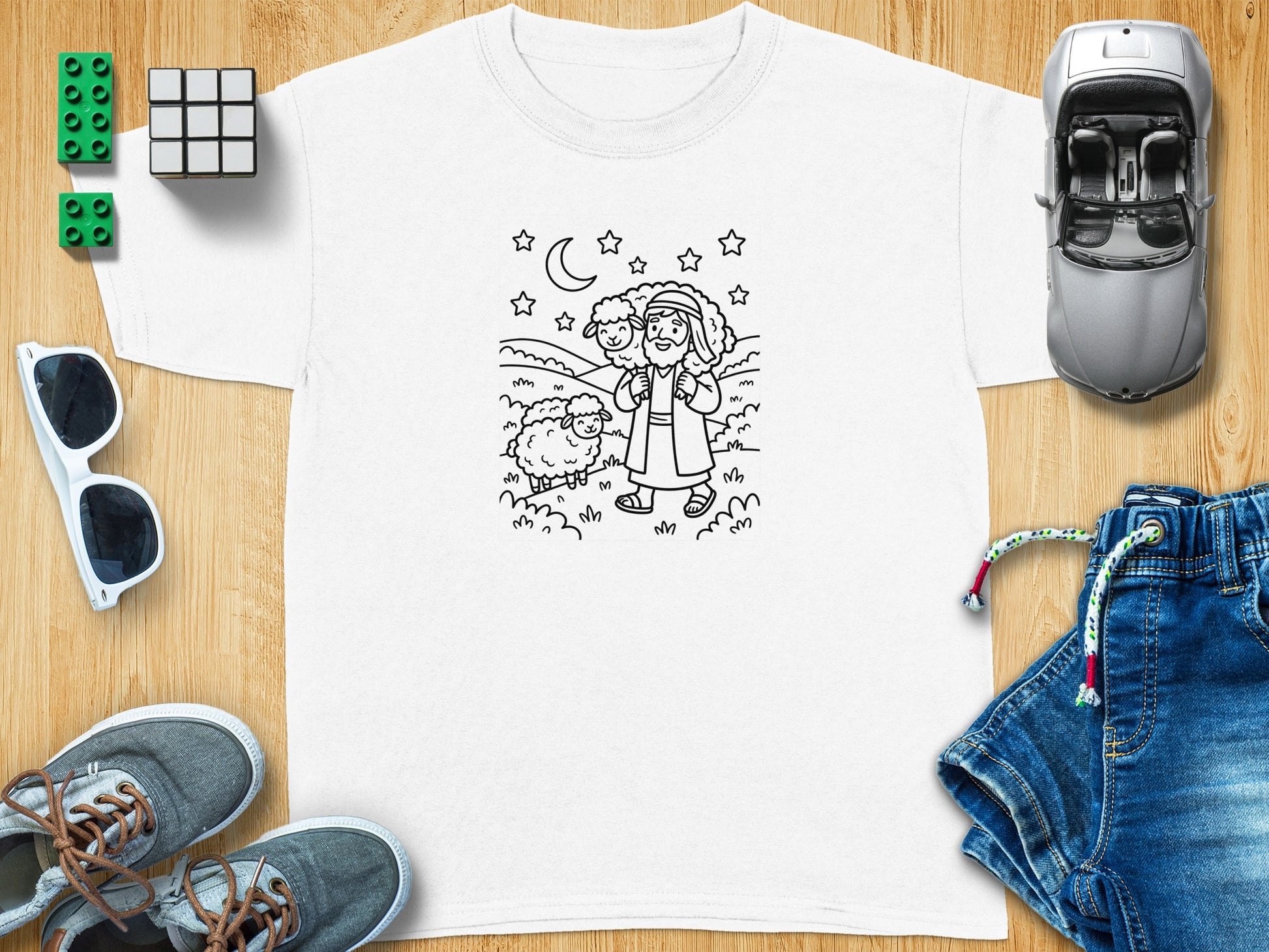 White t-shirt with a black and white line drawing of a shepherd carrying a sheep.
