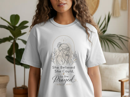 White t-shirt with line art of praying woman and text "She Believed She Could, So She Prayed."