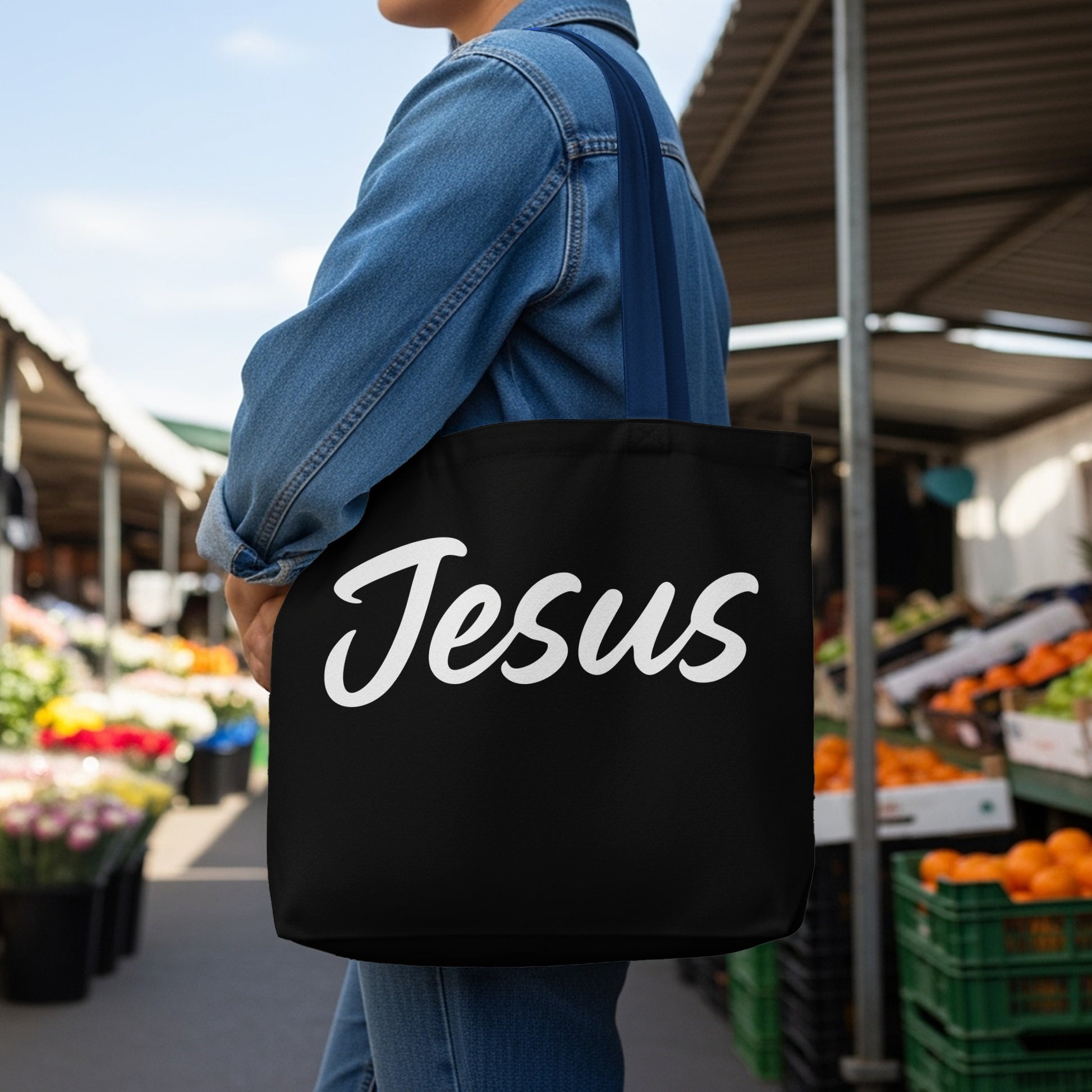 Black tote bag with "Jesus" written in white cursive script.