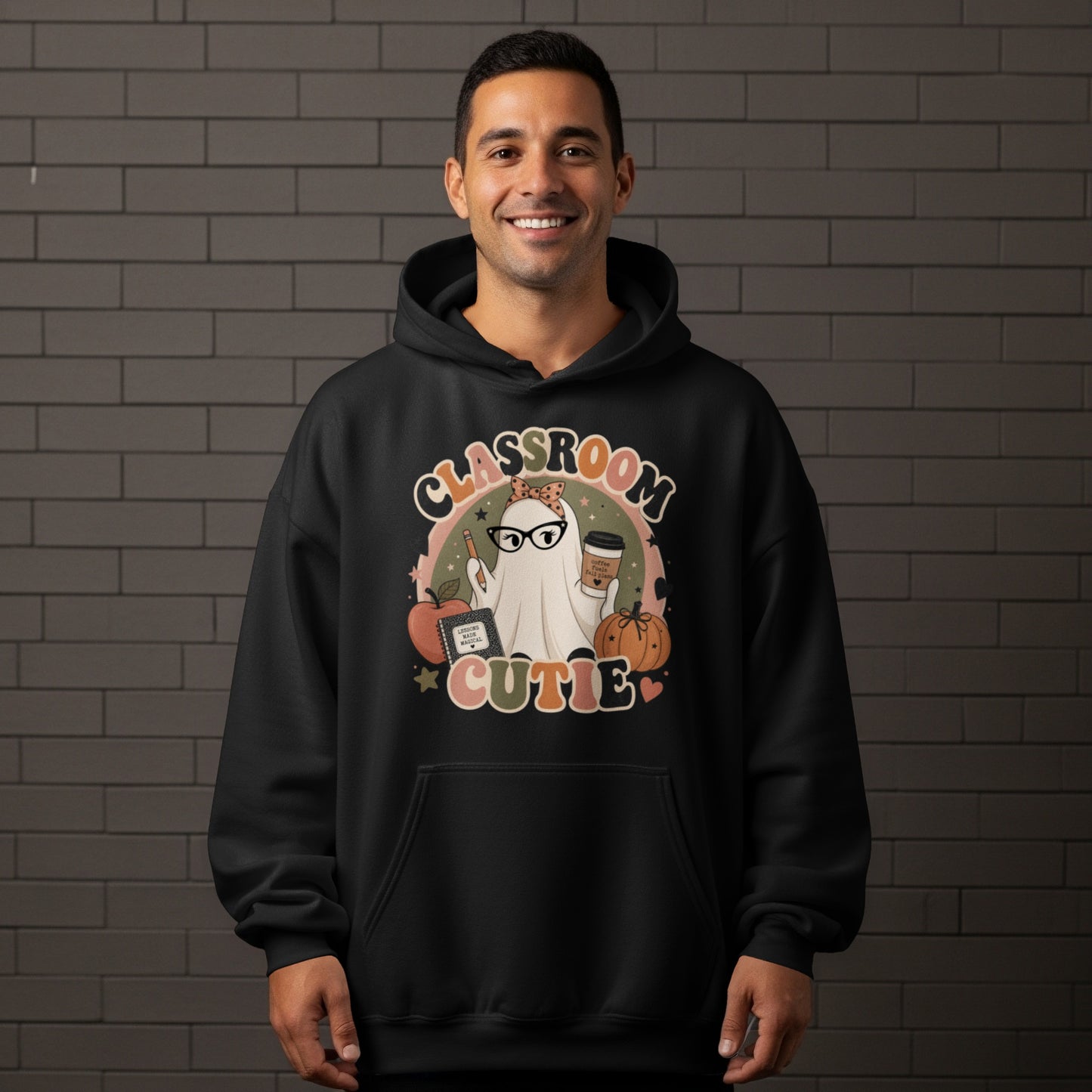 Black hoodie with "Classroom Cutie" ghost, apple, book, and pumpkin graphic.