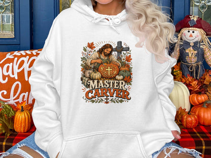 White hoodie with "Master Carver" graphic depicting Jesus carving a pumpkin.