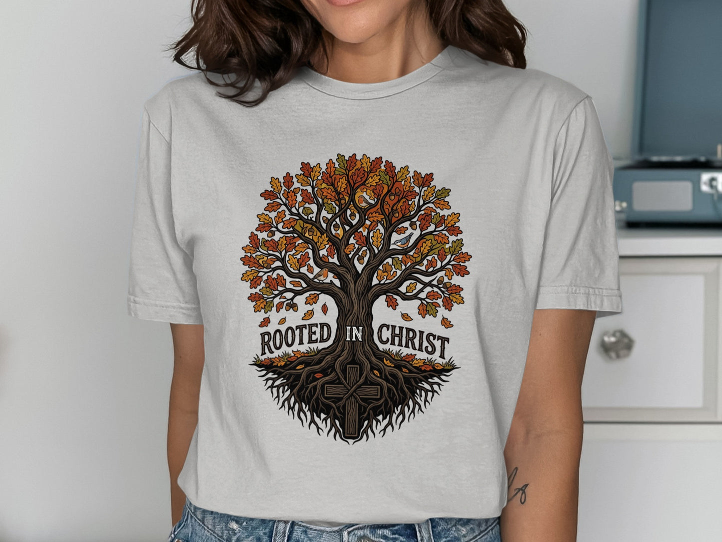 T-shirt graphic of a tree with roots and text "Rooted in Christ."