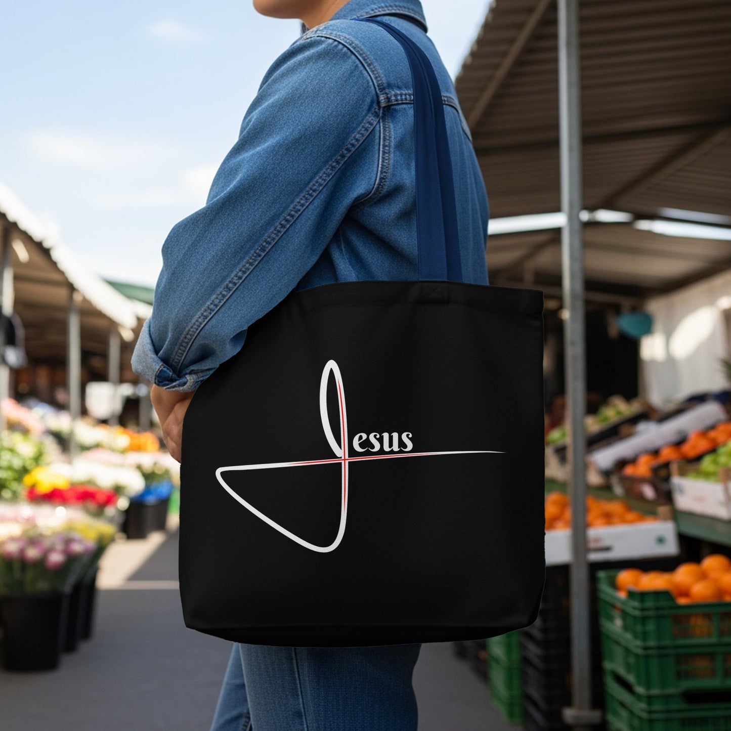 Black tote bag with white and red abstract design and "Jesus" text.