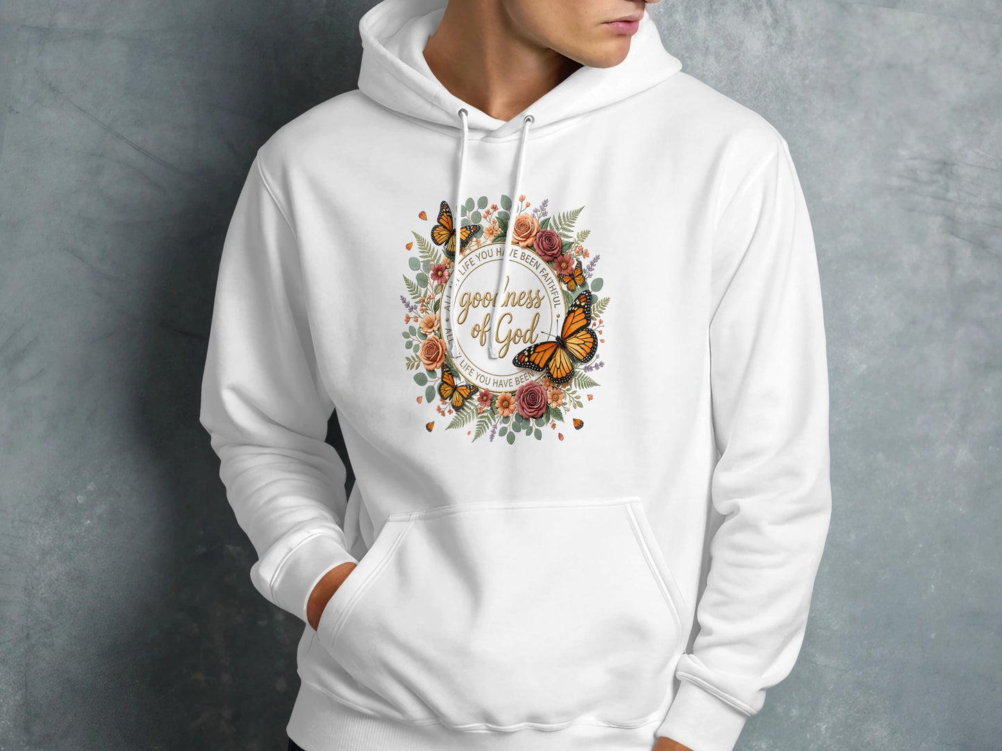 White hooded sweatshirt with floral wreath and "Goodness of God" text.