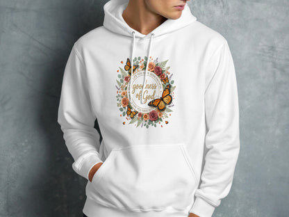 White hooded sweatshirt with floral wreath and "Goodness of God" text.