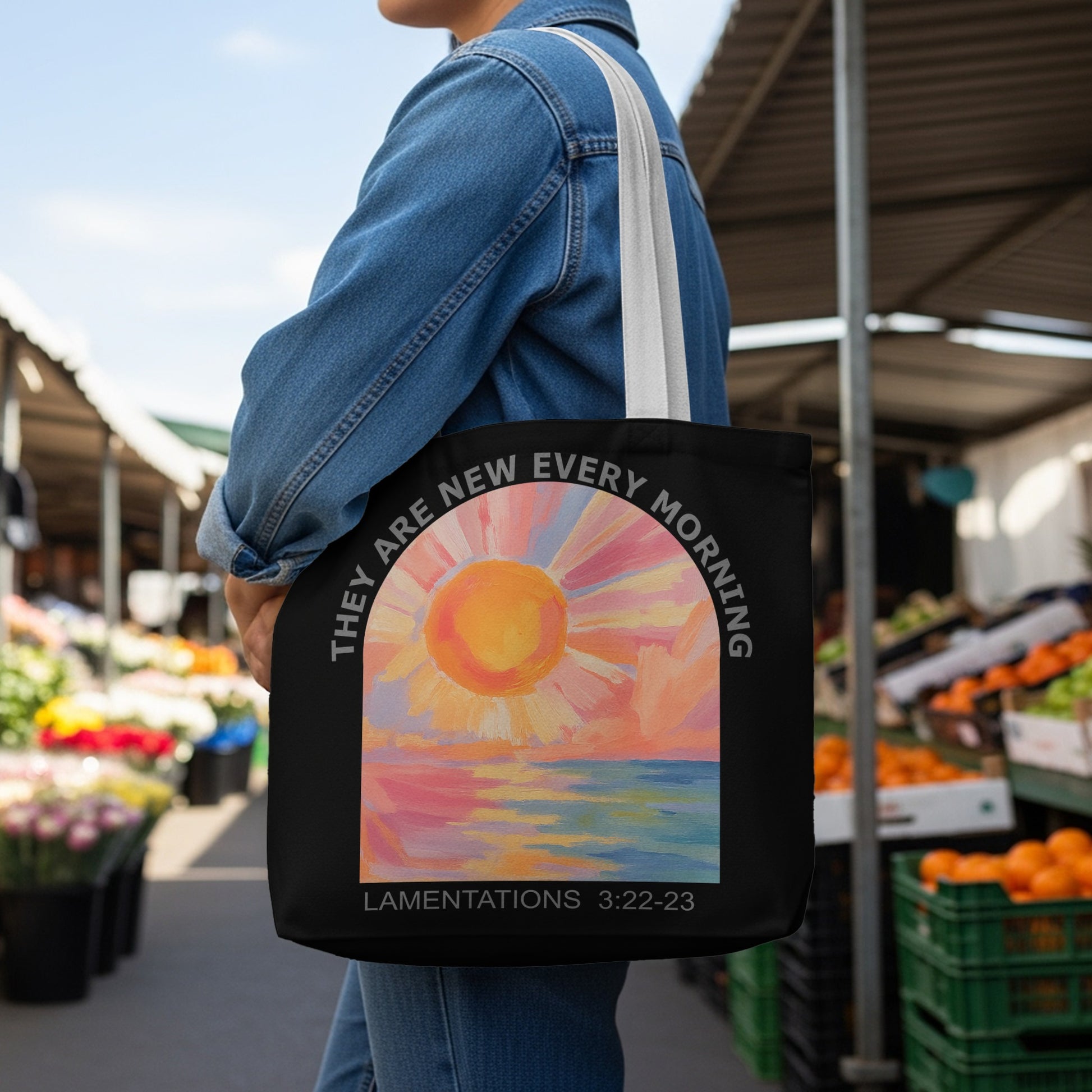 Black tote bag with sunrise over water art and text.