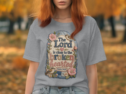 Gray t-shirt with embroidered floral design and text "The Lord is close to the brokenhearted Psalm 34:18".