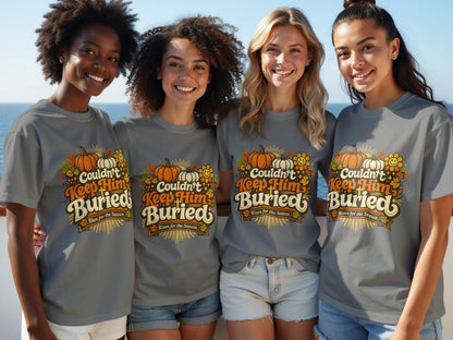 Four women wear gray t-shirts with pumpkins, flowers, and text reading "Couldn't Keep Him Buried Risen for the Season."