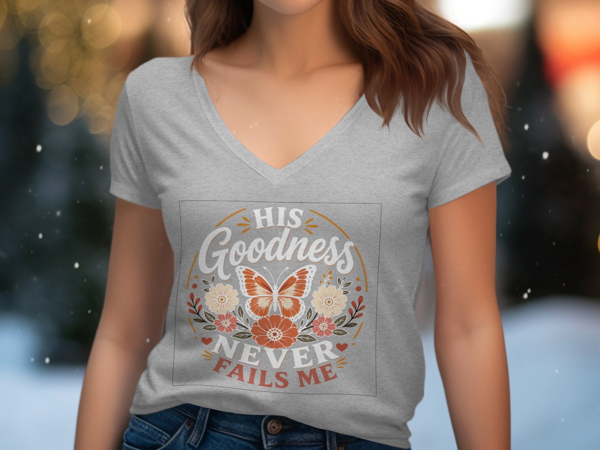 Grey v-neck t-shirt with "His Goodness Never Fails Me" text and butterfly design.