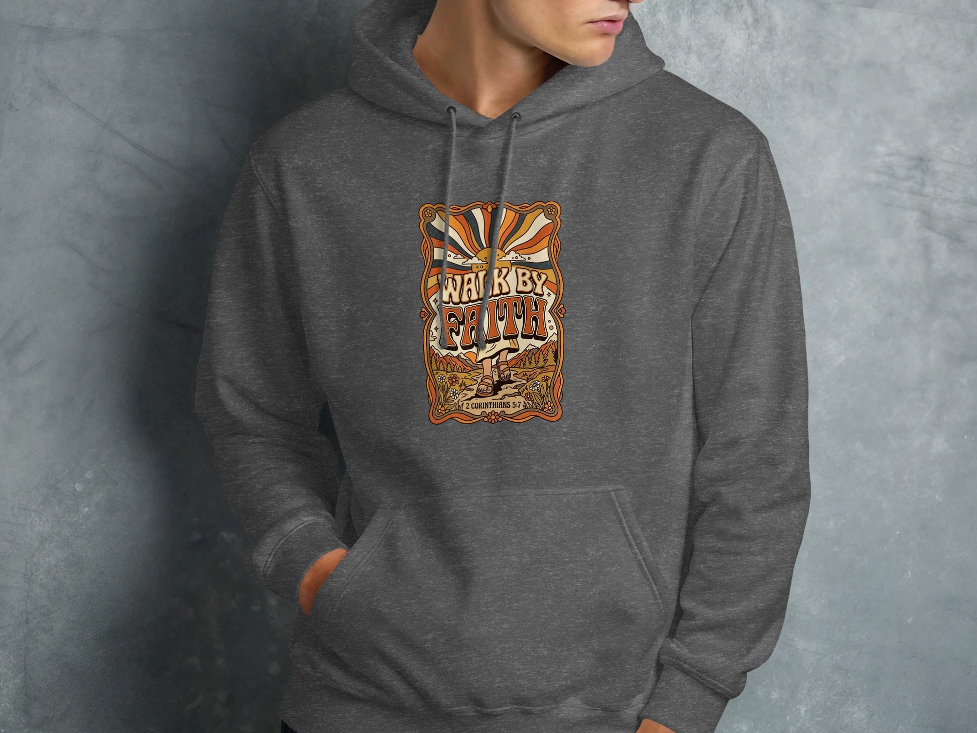 Dark grey hoodie featuring "Walk by Faith" text with sunburst and nature scene.