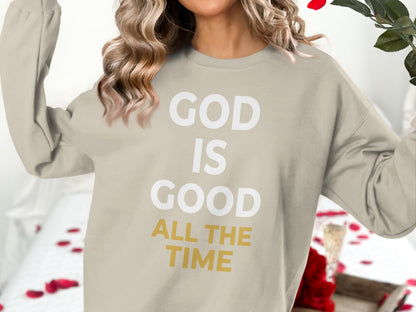 Beige sweatshirt with "GOD IS GOOD ALL THE TIME" text.