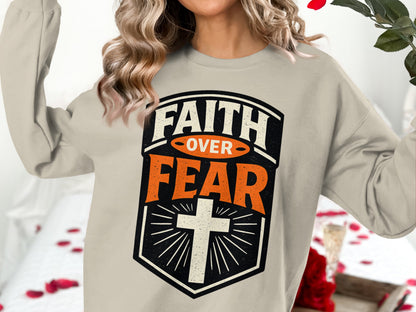 Beige sweatshirt with "FAITH OVER FEAR" and a cross design.