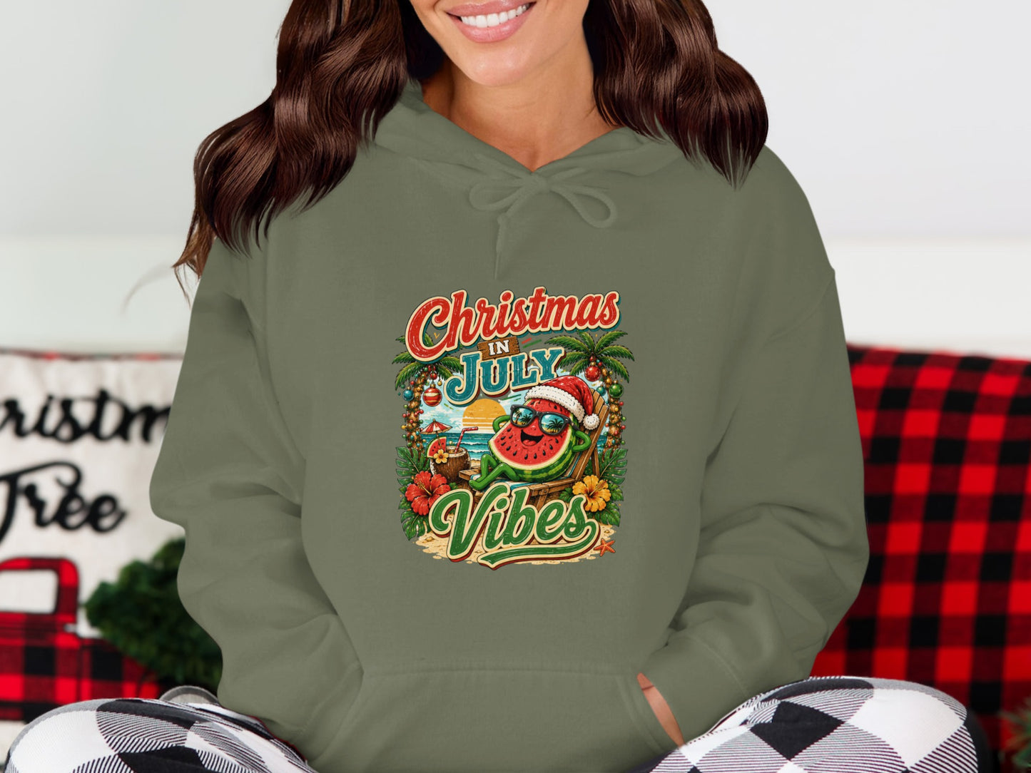 Green hoodie with a graphic of a sunglasses-wearing watermelon on a beach, "Christmas in July Vibes" text.