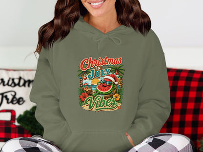 Green hoodie with a graphic of a sunglasses-wearing watermelon on a beach, "Christmas in July Vibes" text.