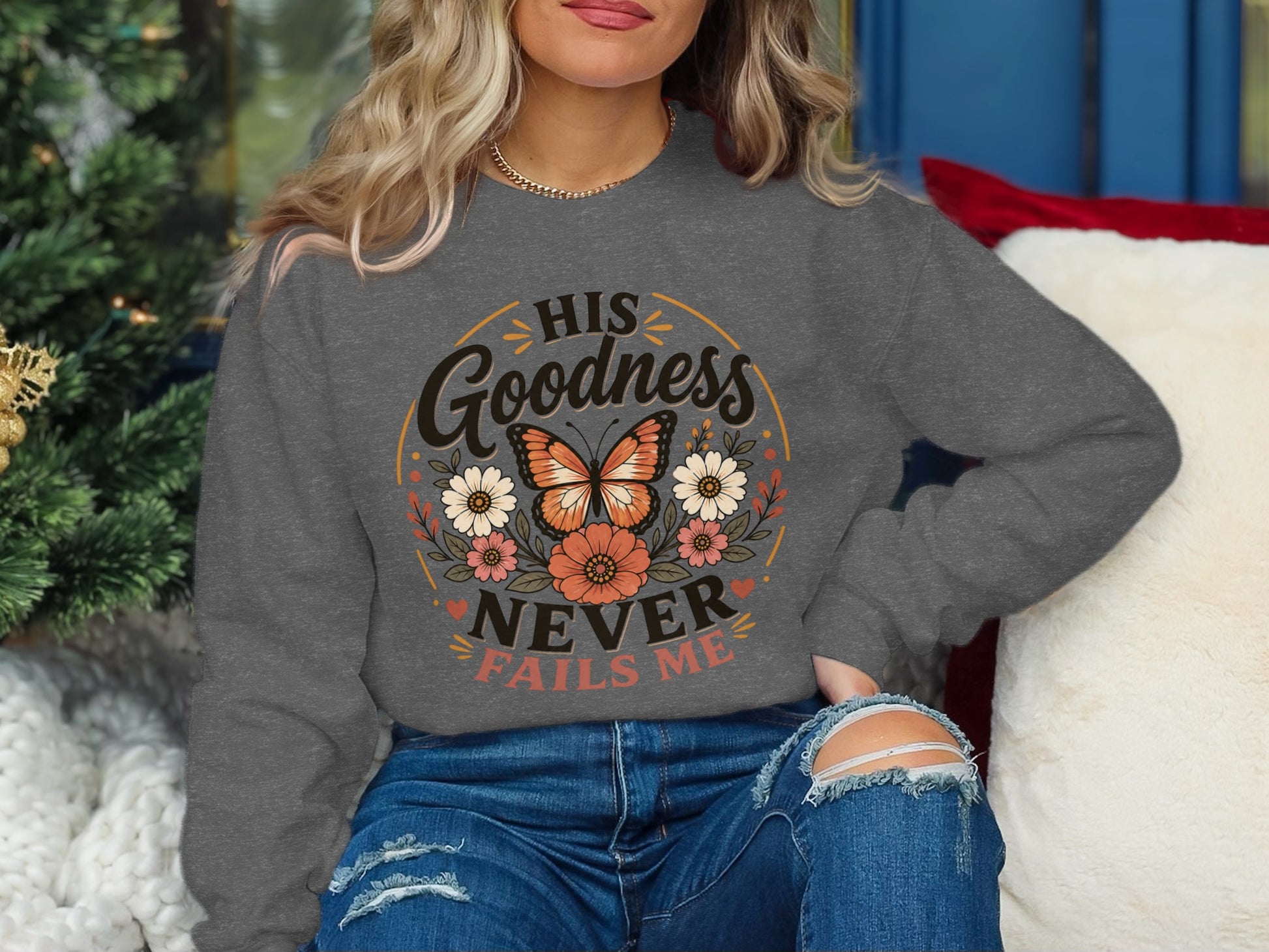 Gray sweatshirt with "His Goodness Never Fails Me" text and butterfly design.