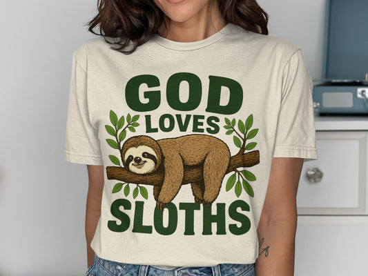 Cream t-shirt with "GOD LOVES SLOTHS" and a sloth on a branch.