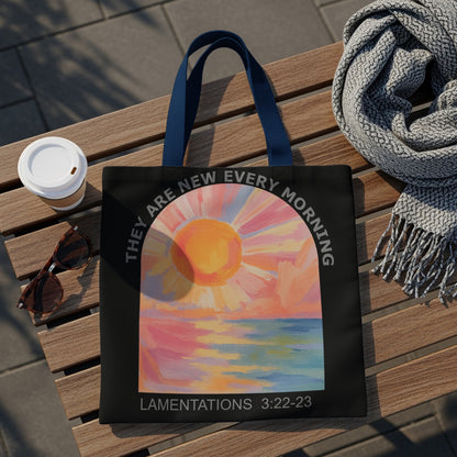 Black tote bag with sunrise over water art and "LAMENTATIONS 3:22-23" text.