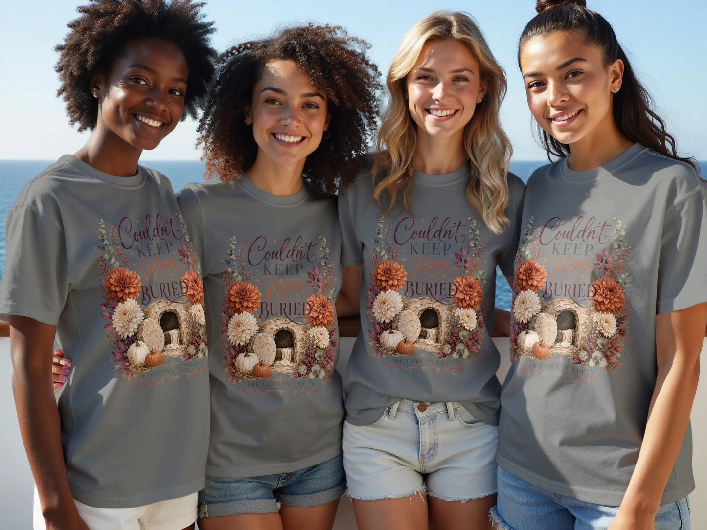 T-shirt with floral graphic of empty tomb, pumpkins, and text "Couldn't Keep Him Buried".