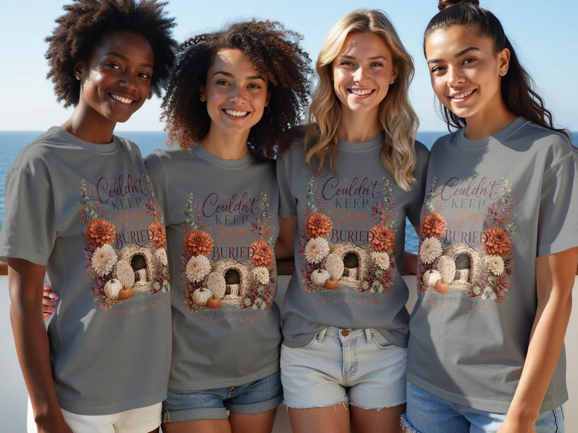 T-shirt with floral graphic of empty tomb, pumpkins, and text "Couldn't Keep Him Buried".