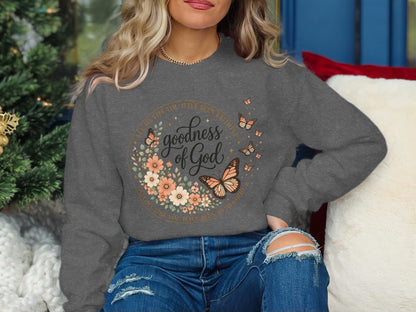 Gray sweatshirt with "goodness of God" floral and butterfly design.