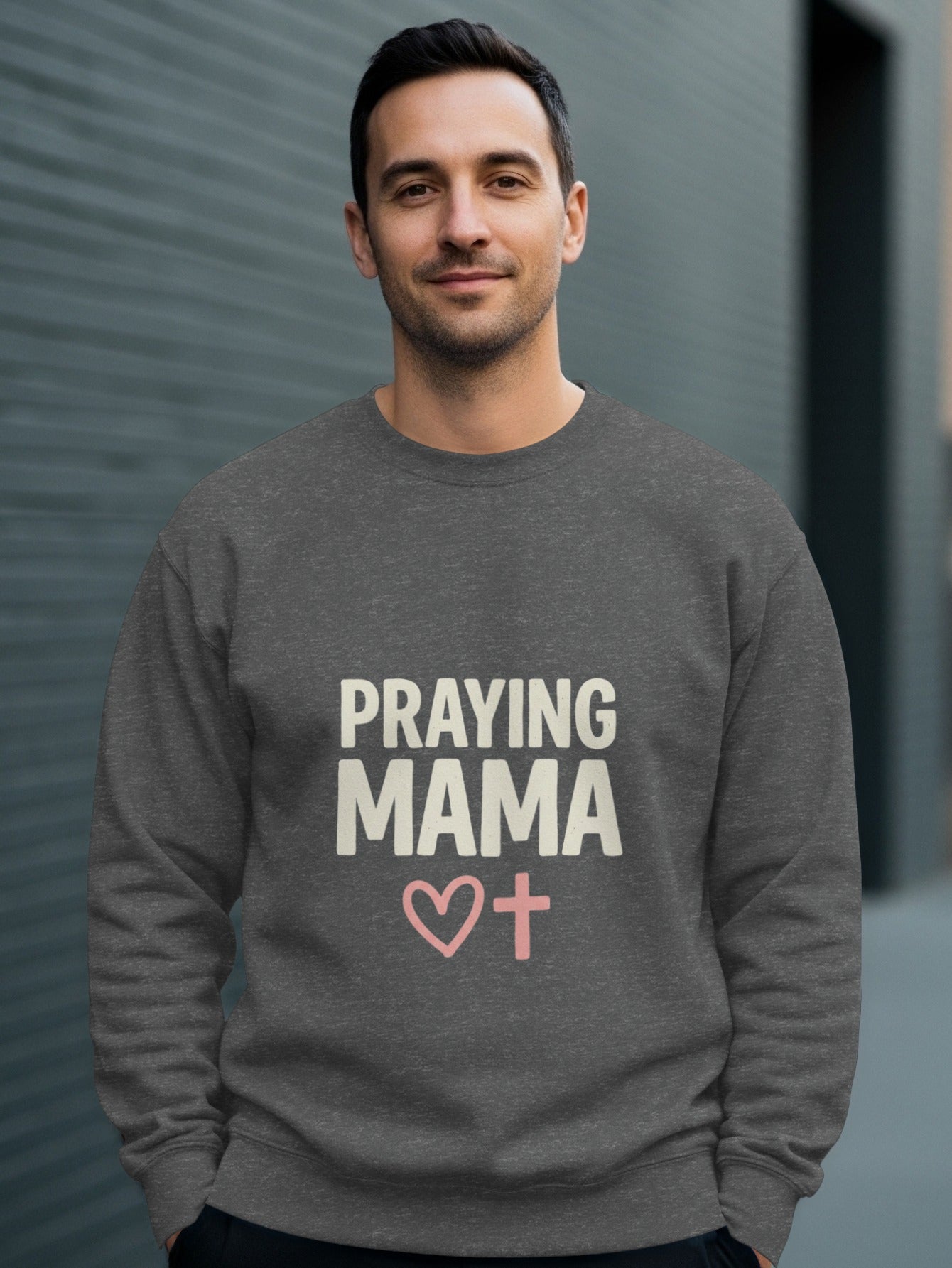 Dark gray sweatshirt with "PRAYING MAMA" text and pink cross with heart.