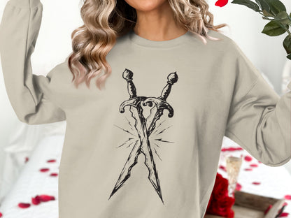 Light tan sweatshirt with a black sketch of two crossed swords.