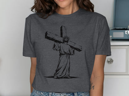 Jesus Christ carrying the cross in black silhouette on a grey t-shirt.