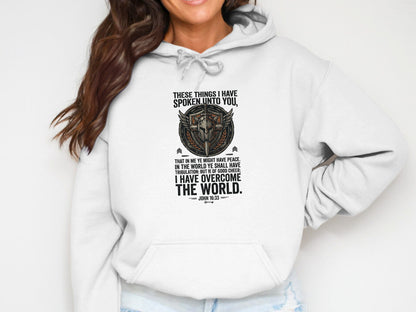 White hoodie with "John 16:33" scripture and shield graphic.