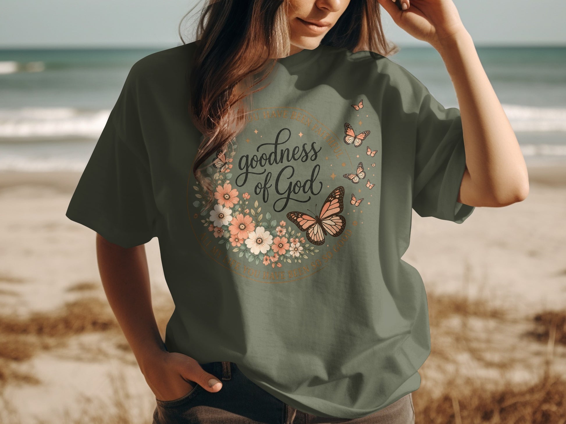 Olive green t-shirt with "Goodness of God" text and floral butterfly design.
