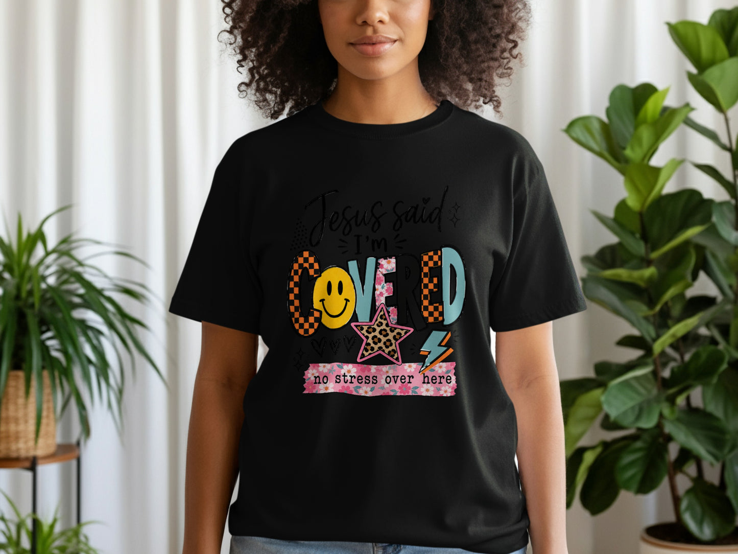 Black t-shirt with "Jesus said I'm Covered no stress over here" graphic.