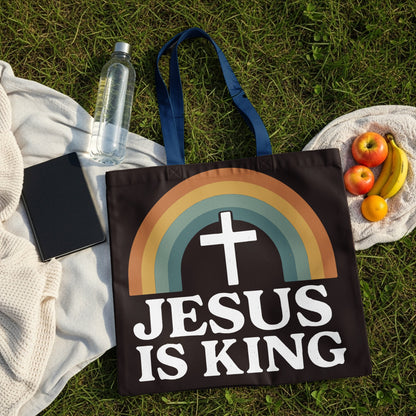 Black tote bag with "JESUS IS KING" text and rainbow cross graphic.